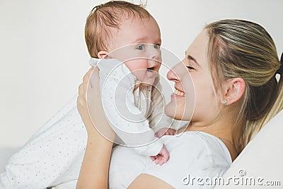 Toned portrait of lying young woman holding her 3 months old baby Stock Photo