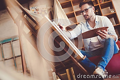 Portrait Of Male Artist Working On Painting In Studio Stock Photo