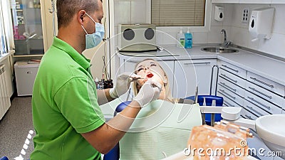 Portrait of male dentist inspecting mouth of young blonde woman Stock Photo