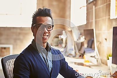 Portrait Of Male Designer Working At Desk In Modern Office Stock Photo