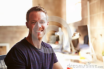 Portrait Of Male Designer Working At Desk In Modern Office Stock Photo