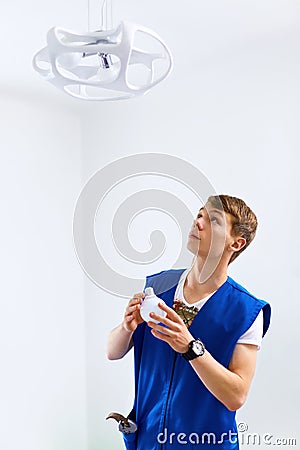 Portrait Of A Male Electrician instaling Lamp Stock Photo