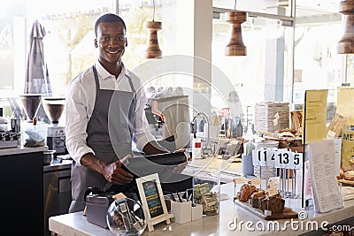 Portrait Of Male Employee Working At Delicatessen Checkout Stock Photo