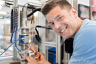 Portrait Of Male Engineer Working On Machine In Factory Stock Photo