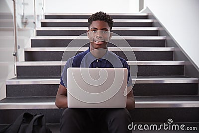 Portrait Of Male High School Student Sitting On Staircase And Using Laptop Stock Photo