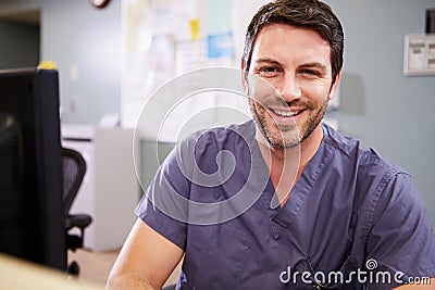 Portrait Of Male Nurse Working At Nurses Station Stock Photo