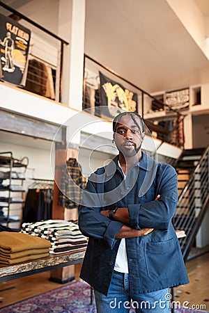 Portrait Of Male Owner Of Fashion Store Standing In Front Of Clothing Display Stock Photo