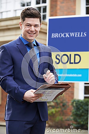 Portrait Of Male Realtor Standing Outside Residential Property Stock Photo