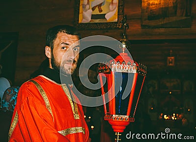 Portrait of a male Sexton in a red dress with a red lantern Stock Photo