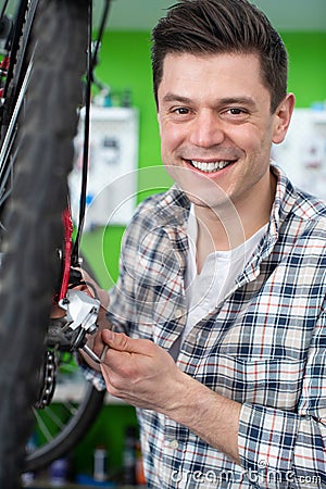 Portrait Of Male Small Business Owner Repairing Gears In Bicycle Repair Shop Stock Photo