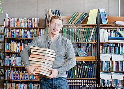 Portrait of a male student with pile books in college library Stock Photo