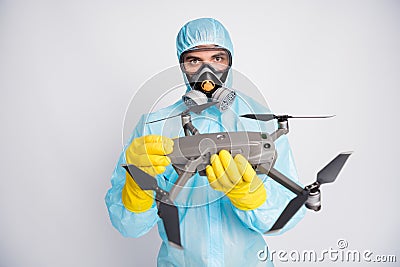 Portrait of man doctor hold robot airplane helicopter drone video filming surface wear white suit hazmat yellow latex Stock Photo