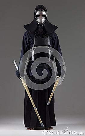 Portrait of man kendo fighter with two bamboo swords in traditional uniform Stock Photo