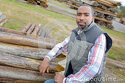 Portrait man next to stack wood Stock Photo