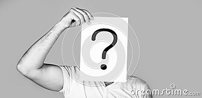 Portrait of man, peeking behind of interrogation symbol. Male isolated. Man a question. Doubtful man holding Question Stock Photo