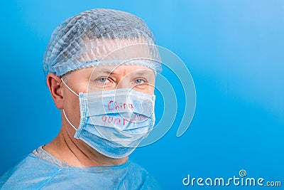 Portrait of man wearing medical uniform and mask with China quarantine word at blue background. Protect your health. Coronavirus Stock Photo