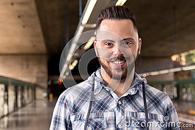 Portrait man wearing plaid shirt waiting for train at subway station. Concept of transport service, mobility Stock Photo