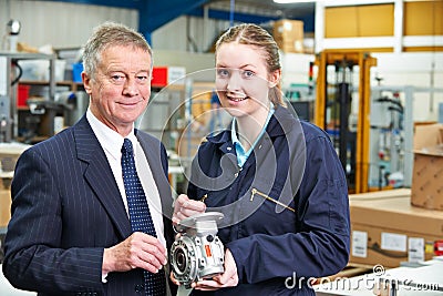 Portrait Of Manager And Apprentice Engineer Inspecting Component Stock Photo