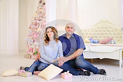 Portrait of married couple that poses and sits on floor against Stock Photo