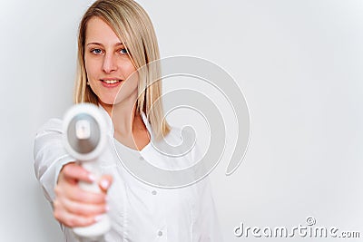 Portrait of master of laser hair removal. Woman in white coat hold laser hair removal device in her hands and show as Stock Photo