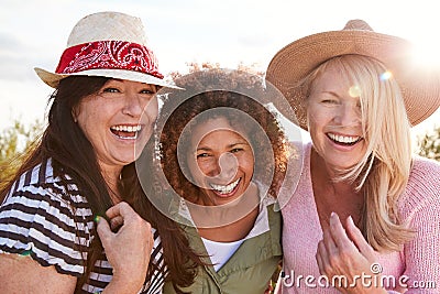 Portrait Of Mature Female Friends Walking Through Field On Camping Vacation Stock Photo