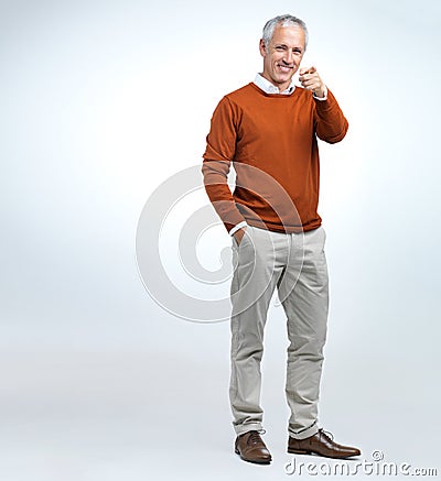 Portrait, mature man and finger pointing in studio with mockup, smile and happiness in white background. Fashion, formal Stock Photo