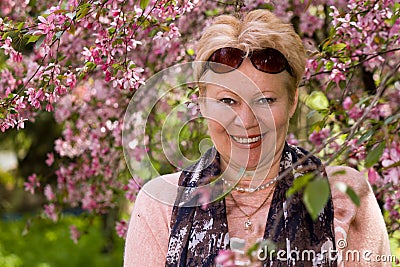 Portrait of mature woman near a decorative apple tree Stock Photo