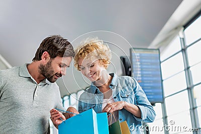 Portrait of mature woman showing present she bought in duty free with her husband at airport Stock Photo