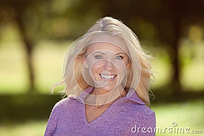 Portrait Of A Mature Woman Smiling At the Camera At The Park Stock Photo