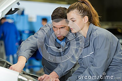 portrait mechanic instructing female apprentice Stock Photo