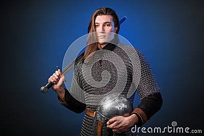 Portrait of a medieval warrior of the late Viking era and the beginning of the Crusades. Knight with long hair in chain mail Stock Photo