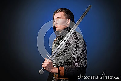 Portrait of a medieval warrior of the late Viking era and the beginning of the Crusades. Knight with long hair in chain mail Stock Photo