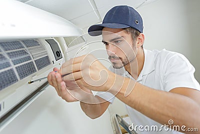 Portrait mid-adult male technician repairing air conditioner Stock Photo