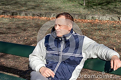 Portrait of a middle aged man sitting on a park bench Stock Photo