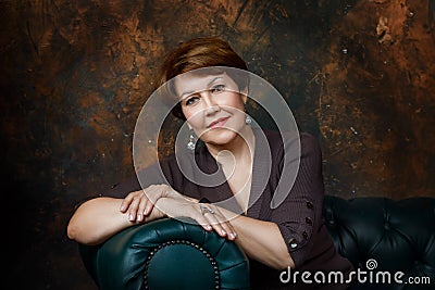 Portrait of a middle aged woman sitting on a sofa Stock Photo