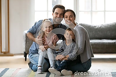 Portrait of millennial couple holding two preschooler kids Stock Photo