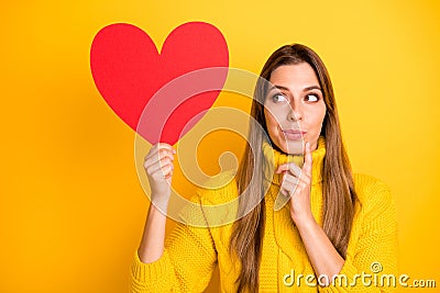 Portrait of minded girl get red big paper card heart from secret admirer think thoughts who he is wear knitted collar Stock Photo