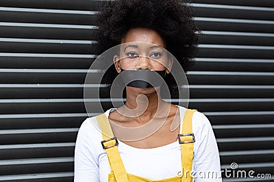 Portrait of mixed race woman having black tape on mouth Stock Photo