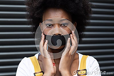 Portrait of mixed race woman having black tape on mouth Stock Photo