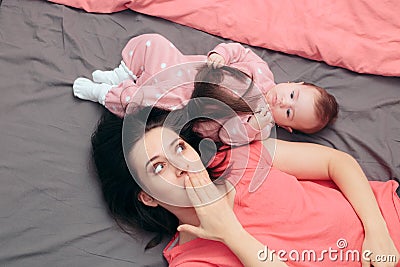 Funny Baby Girl Playing with Motherâ€™s Hair Stock Photo