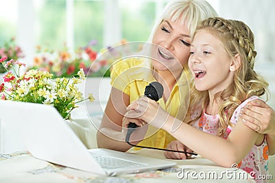 Mother and daughter singing karaoke Stock Photo