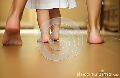 Portrait of a mother teaching baby to walk indoors Stock Photo
