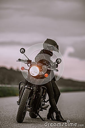 Portrait of motorcyclist woman using mobile phone, smartphone during stop. Young driver biker uses a navigator. Stock Photo