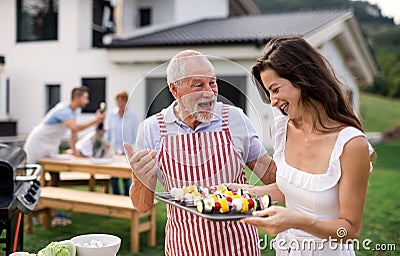 Portrait of multigeneration family outdoors on garden barbecue, grilling. Stock Photo