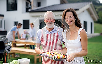 Portrait of multigeneration family outdoors on garden barbecue, grilling. Stock Photo
