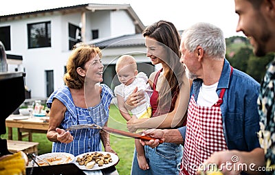 Portrait of multigeneration family outdoors on garden barbecue, grilling. Stock Photo