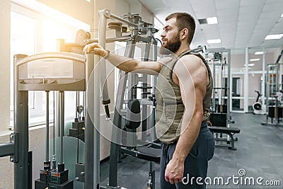 Portrait muscular caucasian bearded man dressed in weighted vest in the gym, military style Stock Photo