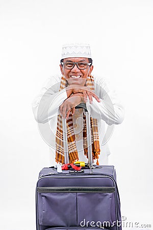 Portrait muslim old asian man with travel suitcase. going for ramadan eid mubarak celebration concept isolated over a white Stock Photo