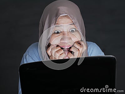 Muslim Woman Terrified Watching Hooror Movie on Streaming Media Stock Photo