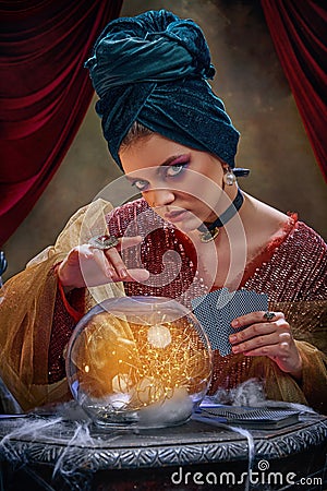 Portrait of mysterious soothsayer and molfarka guesses and predicts fate. Retro circus, mysticism and witchcraft Stock Photo